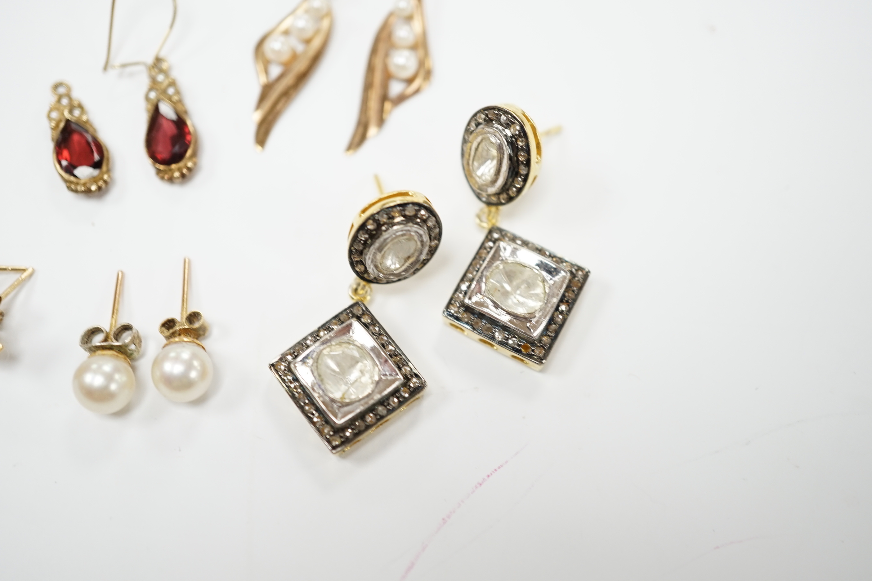 A modern pair of 9ct and garnet? earrings, a pair of Indian? yellow metal and diamond cluster set drop earrings and three other pairs of yellow metal earrings including single stone cultured pearl.